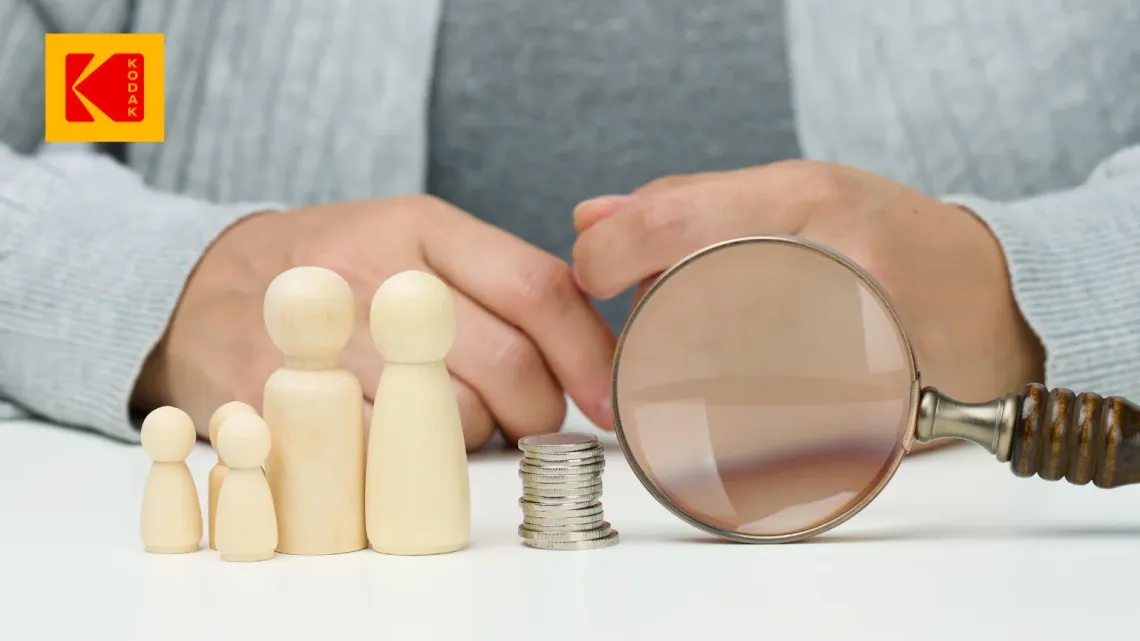 Une image d'une loupe, de quelques pièces de monnaie et de silhouettes découpées en bois représentant une famille.