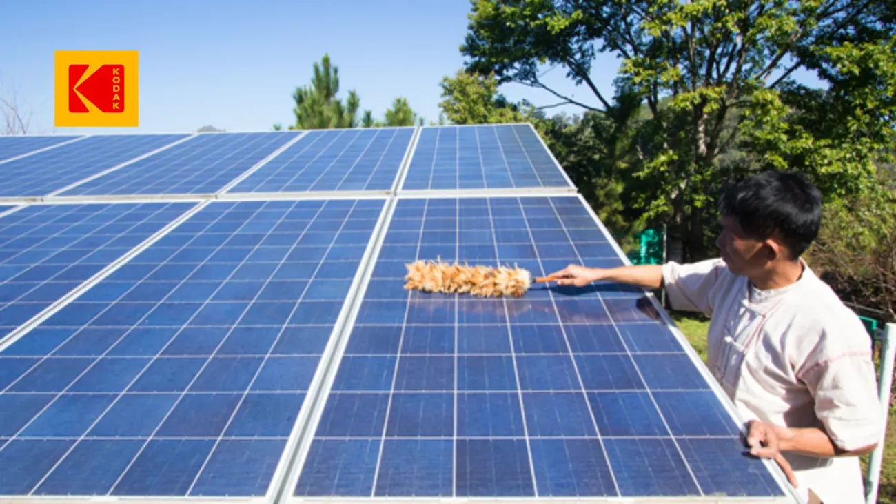 Un homme brossant délicatement un panneau solaire.